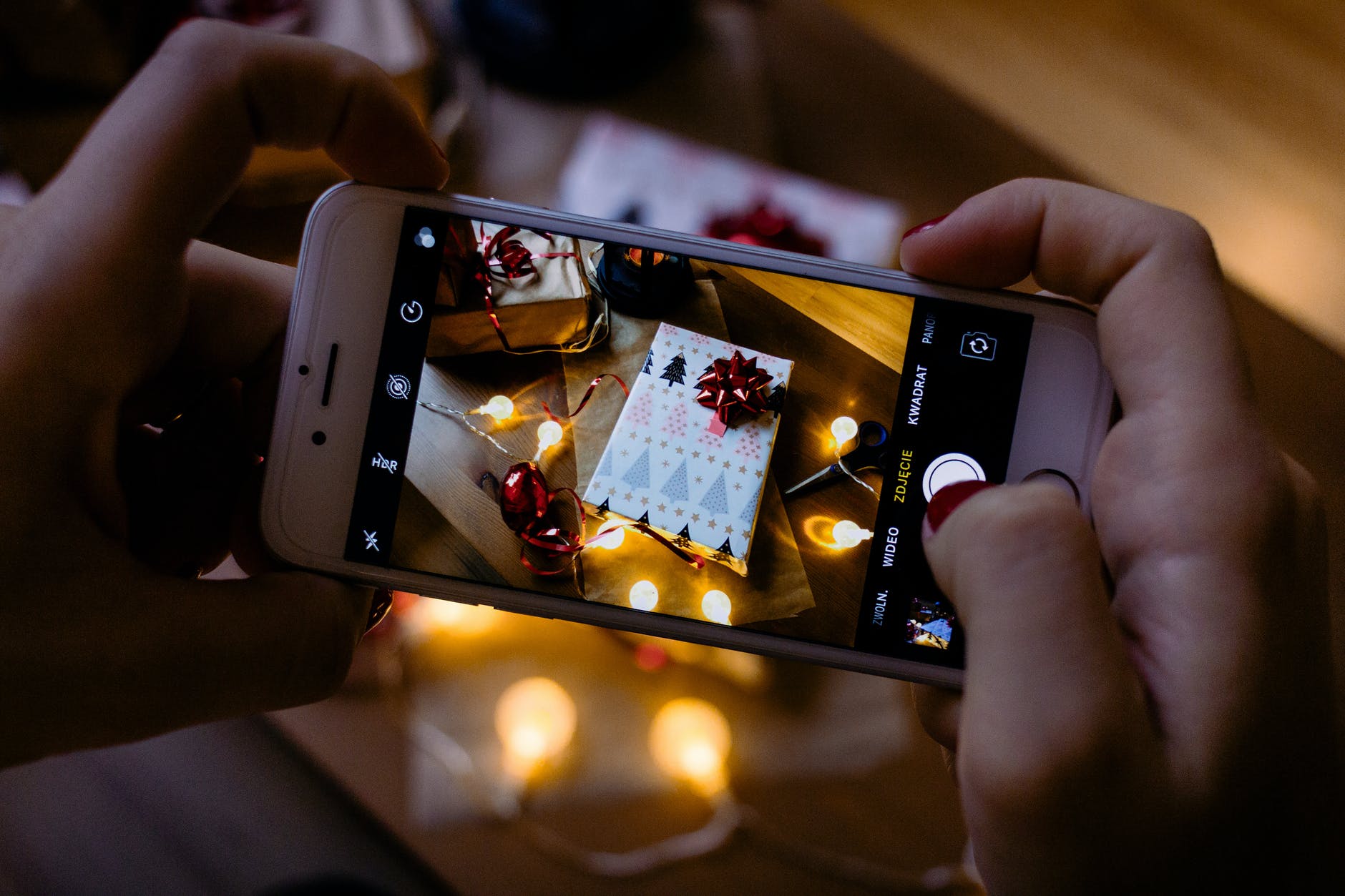 person using iphone taking picture of gift box boîte cadeau techno